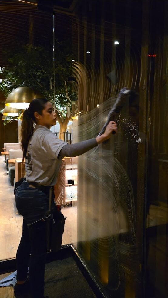 Real Clean technician hand-detailing interior glass on a Las Vegas home